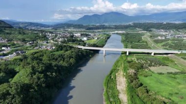 Yeşil arazi ve köprü boyunca akan nehrin havadan görünüşü
