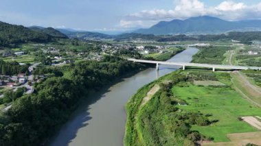 Yeşil arazi ve köprü boyunca akan nehrin havadan görünüşü