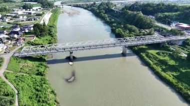 Köprünün altından akan nehir manzarası yeşilliklerle çevrili.