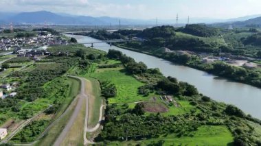 Yeşil tarlalar ve tepelerle çevrili nehrin havadan görünüşü