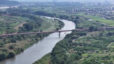 Yeşil arazi ve köprü boyunca akan nehrin havadan görünüşü