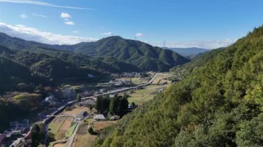 Açık mavi gökyüzünün altındaki dağların ve vadilerin manzarası