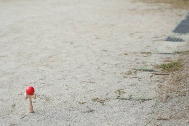 Kırmızı bir top bir tarlada tahta bir sopanın üzerinde oturur. Sahne sessiz ve huzurlu. Başka kimse ya da nesne görünmüyor.