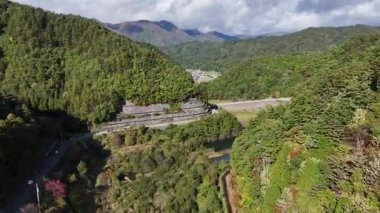 Yeşil dağların ve kıvrımlı nehir manzarasının havadan görünüşü