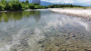 Temiz nehir suyu, pürüzsüz taş ve çakıl taşlarının üzerinde akıyor.