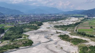 Kuru nehir yatağının yeşil manzarayla çevrili havadan görünüşü