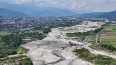 Yeşil tepeler ve dağlarla çevrili nehir yatağının havadan görünüşü