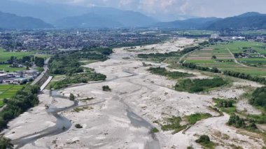 Kuru nehir yatağının ve çevreleyen yeşil manzaranın havadan görünüşü