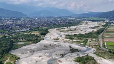 Dağlar ve yeşilliklerle çevrili nehir yatağının havadan görünüşü
