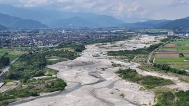 Kuru nehir yatağının yeşil bitki örtüsüyle çevrili havadan görünüşü