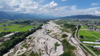 Yeşil tarlalar ve dağlarla çevrili nehir yatağının havadan görünüşü