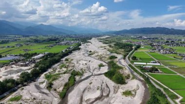 Yeşil tarlalar ve dağlarla çevrili nehir yatağının havadan görünüşü
