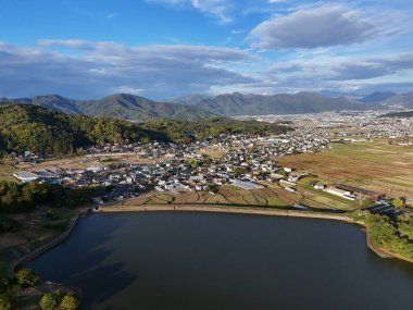 Arka planda göl olan bir şehir. Göl bir orman ve dağlarla çevrilidir. Şehir küçük ve huzurlu bir atmosferi var.