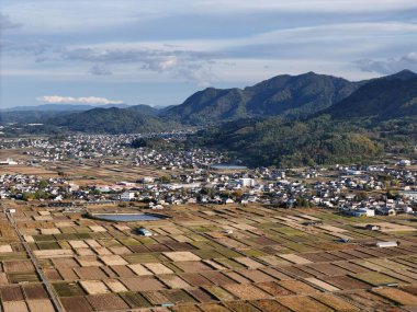 Bir sürü evi ve büyük bir su kütlesi olan kırsal bir kasaba. Kasaba dağlarla çevrili.