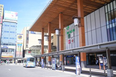 Bir sürü penceresi ve büyük ahşap çatısı olan büyük bir bina. Binanın önünde mavi bir otobüs var.