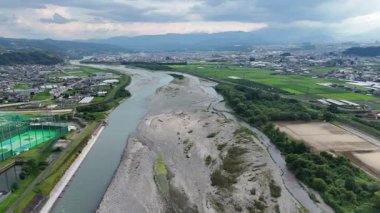 Yeşil arazide akan nehrin havadan görünüşü