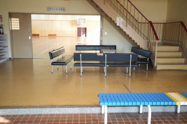 Mavi banklı ve siyah banklı bir oda. Oda bomboş. Duvarda 