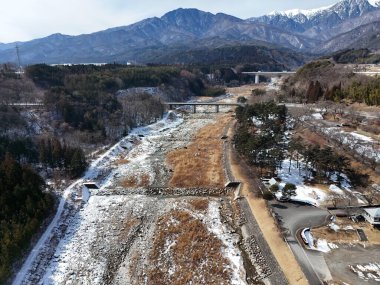 Karlı bir dağ sırasının içinden geçen bir yol. Yol karla kaplı ve o terk edilmiş.