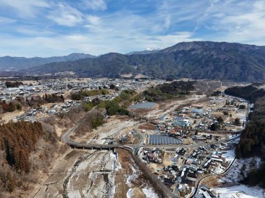 Altında nehir akan ve arkasında dağlar olan bir şehir. Şehir küçük ve huzurlu bir atmosferi var.
