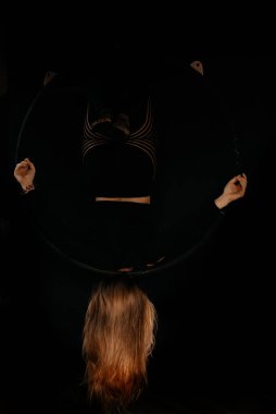 Genç bir jimnastikçi kız jimnastik ringinde egzersiz yapıyor. Jimnastikçi akrobatik öğeler gösteriyor. Jimnastik ve spor konsepti.