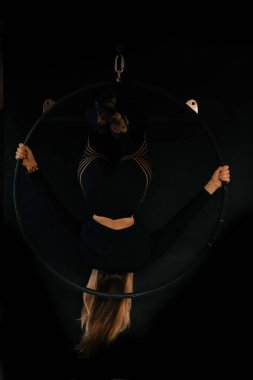 Genç bir jimnastikçi kız jimnastik ringinde egzersiz yapıyor. Jimnastikçi akrobatik öğeler gösteriyor. Jimnastik ve spor konsepti.