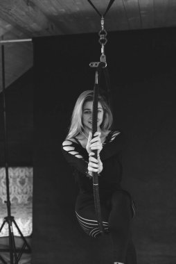 Kız havada akrobatik elementler sergiliyor. Hava jimnastikçisi. Jimnastik ve spor kavramı. Siyah beyaz fotoğraf.