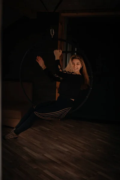 Изящная Молодая Женщина Исполняет Акробатический Элемент Воздушном Кольце Темной Комнате — стоковое фото