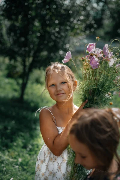 白いドレスの少女は手に大きな美しい野の花の花束を持っています 夏休みだ 幸福と静けさの概念 子供時代の世話 — ストック写真