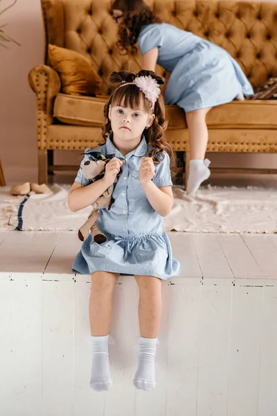 Ein Mädchen Blauen Kleid Sitzt Mit Einem Spielzeug Der Hand — Stockfoto