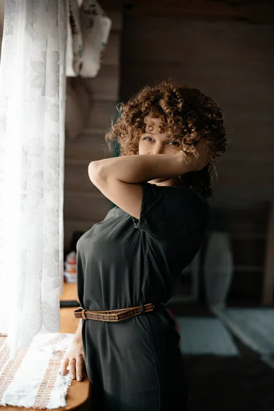 Close Girl Dark Green Dress Curly Hair Stands Windowsill Smiles — Stock Photo, Image