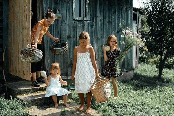 子供たちは 母親が家の中で家をきれいにするのを助け 小さな女の子は白いドレスにカジンカを手にしています 夏休みだ 幸福と静けさの概念 子供時代の世話 — ストック写真