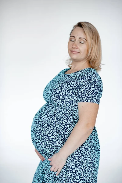 青いドレスの白い背景に妊娠中の笑顔の女の子 育児の概念 家族の話だ 母の日 コピースペース トーニング — ストック写真