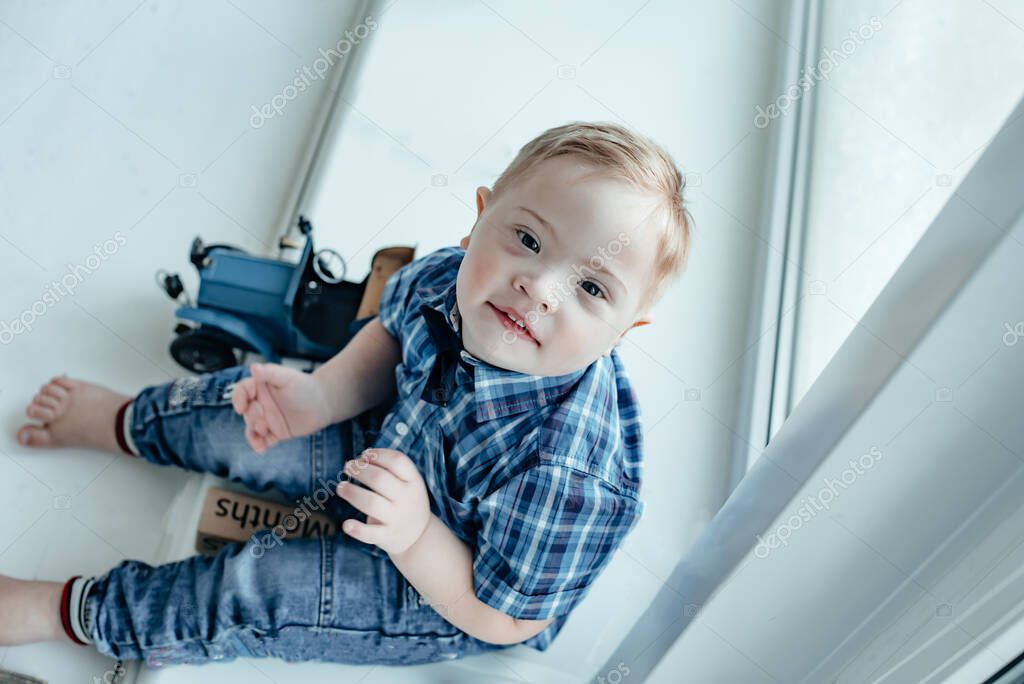 little boy with Down Syndrome with a toy car