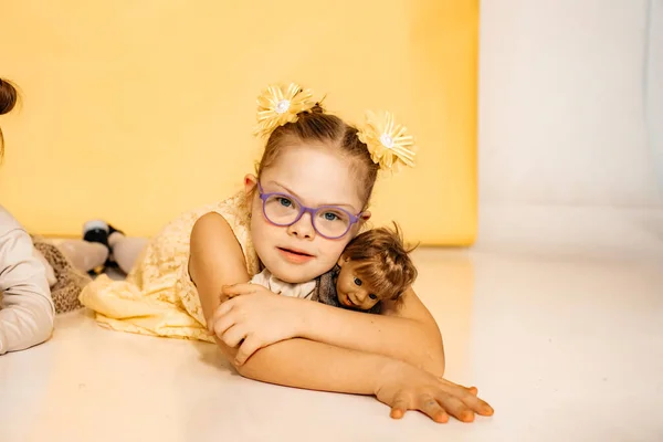 Niño Yace Suelo Sobre Fondo Amarillo Sosteniendo Una Pequeña Muñeca —  Fotos de Stock