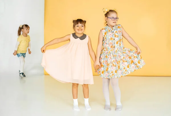 Dos Niñas Con Vestidos Bailan Estudio Sobre Fondo Amarillo Niño —  Fotos de Stock