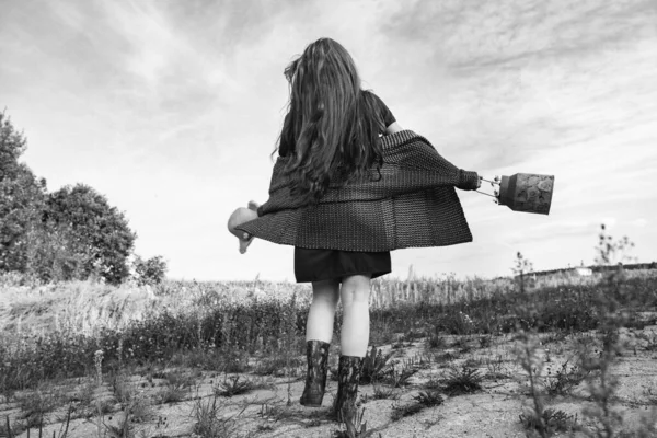 森林附近的一张黑白照片 照片上的女孩穿着长发 手里拿着一顶帽子 那女孩到乡下去散散步 — 图库照片
