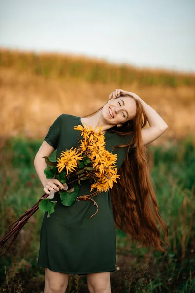 一个红头发的漂亮姑娘采了一束黄色的花 在乡间散步 田边卖花的姑娘 — 图库照片