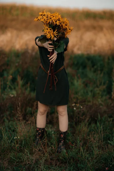 長い赤い髪をした美しい少女が黄色い花の花束を集めた 田舎を散歩してる 畑の近くに花が咲く女の子 — ストック写真