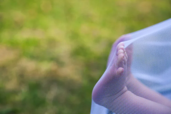 Los pies recién nacidos empujando una mosquitera — Foto de Stock