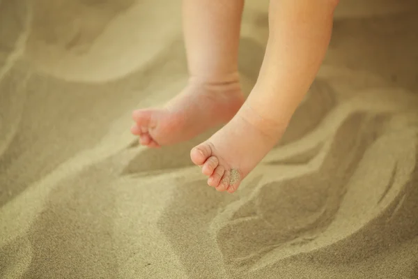 Novorozené dítě nohy v písku — Stock fotografie