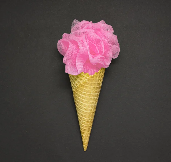 Ice cream puff. Creative concept photo of a waffle cone with a bath puff on black background.