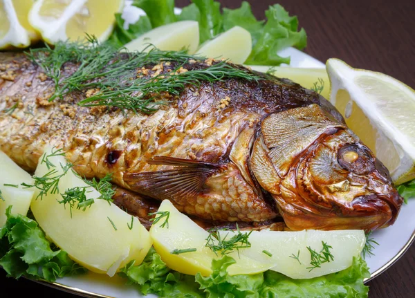 Patates ve limon ile fırında pişmiş sazan