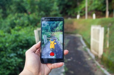  Pokemon Go yükleme bir cep telefonu tutan el