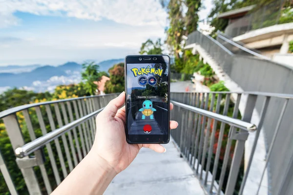  Pokemon Go yükleme bir cep telefonu tutan el
