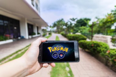 Bir akıllı telefon tutarak ve Pokemon Go oynayan bir kişi el görünümü kapatın