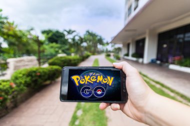 Bir akıllı telefon tutarak ve Pokemon Go oynayan bir kişi el görünümü kapatın