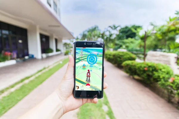 Bir akıllı telefon tutarak ve Pokemon Go oynayan bir kişi el görünümü kapatın