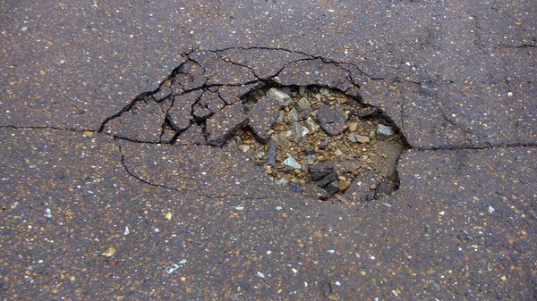 道路の水の浸食 壊れたアスファルトの背景 危険穴 石灰色の背景 — ストック写真