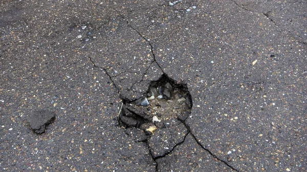 道路の水の浸食 壊れたアスファルトの背景 危険穴 石灰色の背景 — ストック写真