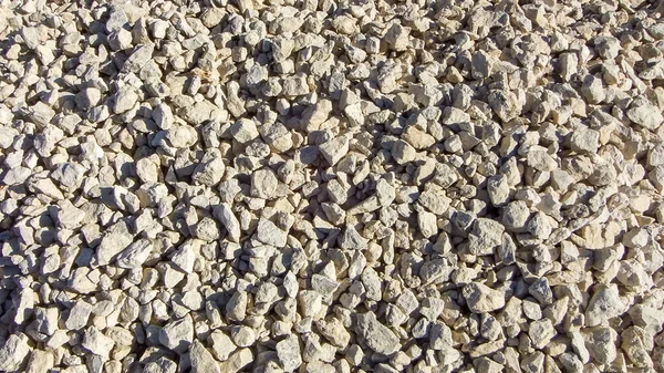 現代の砂利の質感 小さな石 小さな岩 白の色の多くの色合いの小石 砕いた形の小さな乾燥した石の背景 採石場や鉱山の小さな岩の質感 — ストック写真